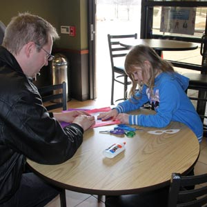 Little girl and father working on arts and crafts